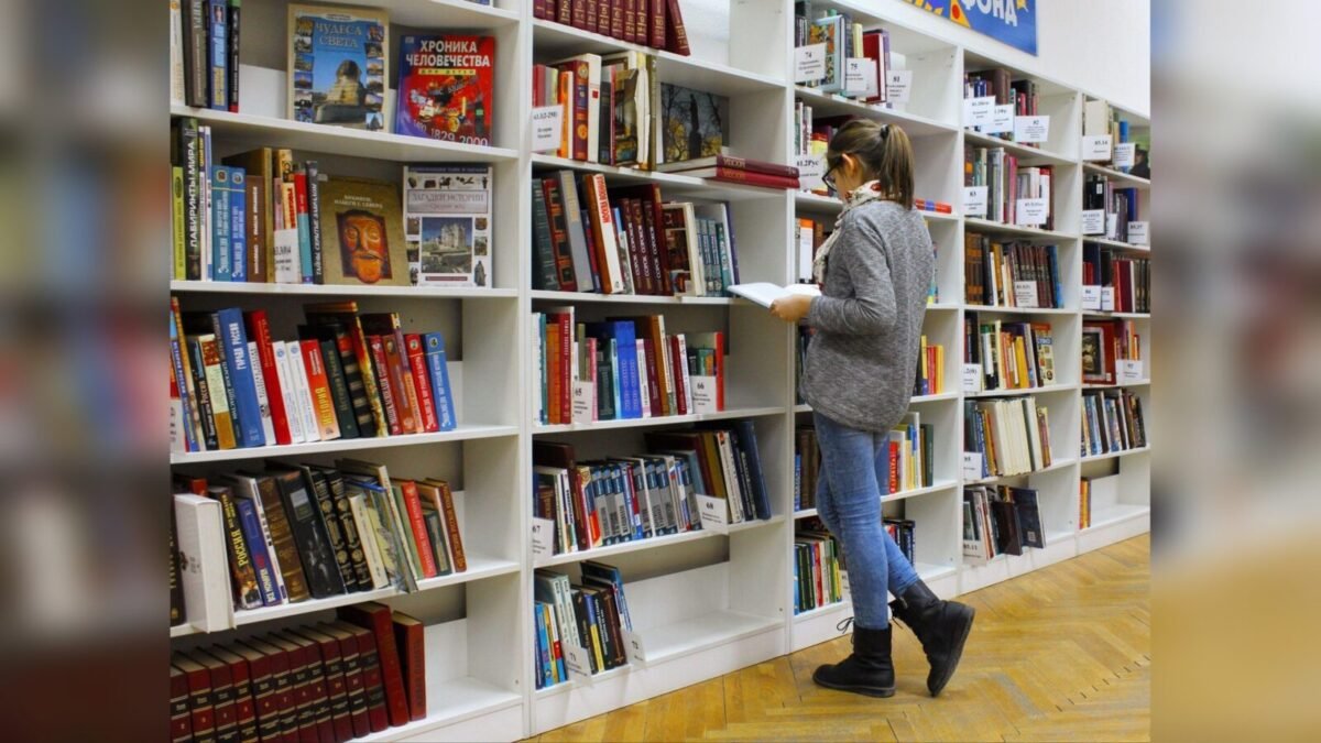 Reader browsing shelves of books in a library